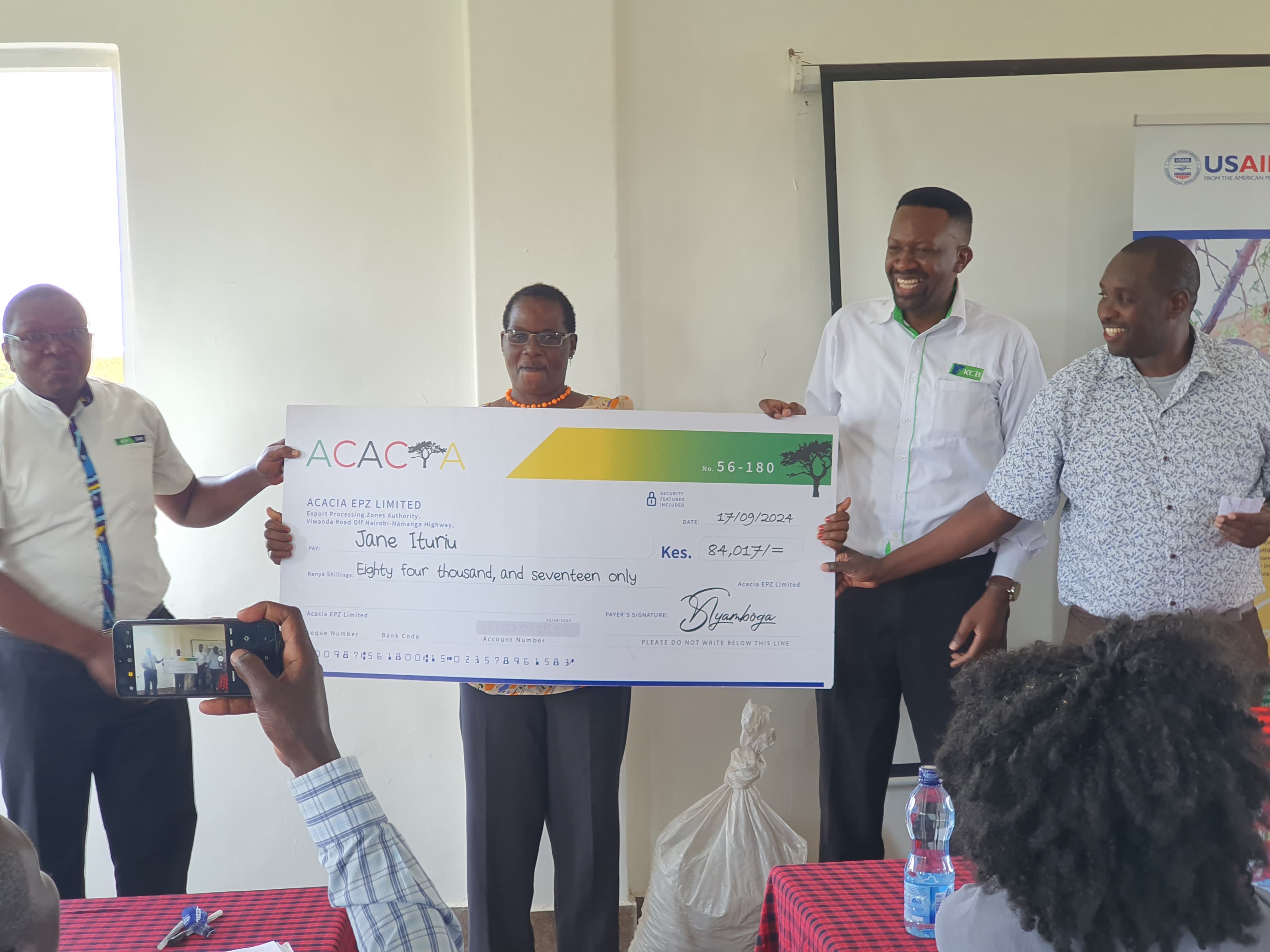 Jane Ituriu receiving her Revolving Fund bonus cheque