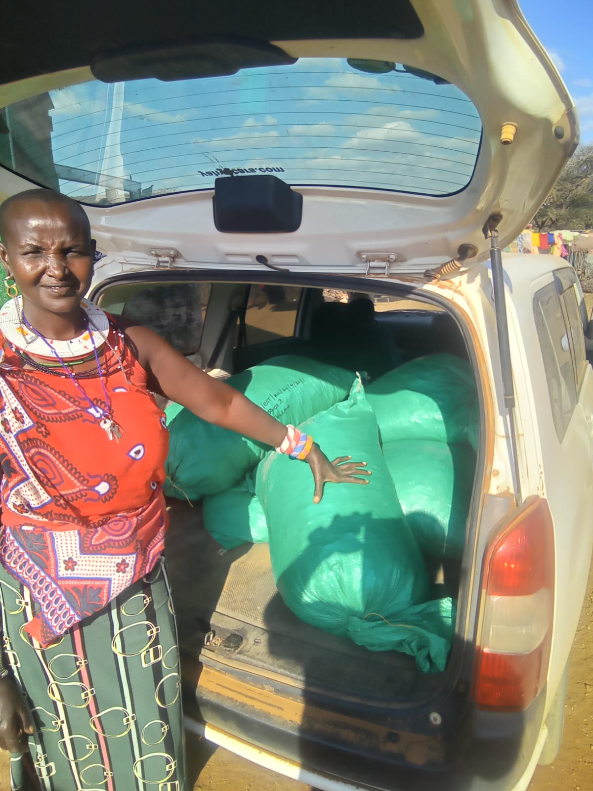 Woman collector with branded gum arabic bags